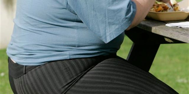 FILE - In this Wednesday, Oct. 17, 2007 file photo, an overweight person eats at a bench in London. The European Court of Justice says obesity can be a disability, a ruling that could have consequences for employers across the continent. The court ruled Thursday, Dec. 18, 2014 in the case of a Danish child-minder who says he was unfairly fired for being fat. The court said if obesity hinders "full and effective participation in professional life, it could count as a disability. Discrimination on the grounds of disability is illegal under European Union law. (AP Photo/Kirsty Wigglesworth, file)