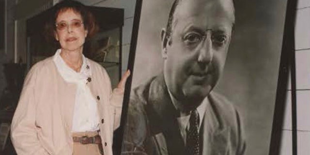 In this 2002 photo provided by Bart Bragg, author and film historian, Betty Lasky, poses with a portrait of her father, Jesse L. Lasky, at the Lasky-DeMille Barn, now the Hollywood Heritage Museum, in Los Angeles.
