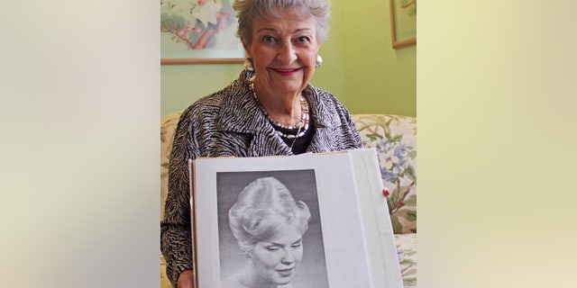 FILE - Jan. 19, 2011:Retired hairstylist Margaret Vinci Heldt with a photo of a model with a "beehive" hairdo from the February 1960 edition of Modern Beauty Shop magazine.