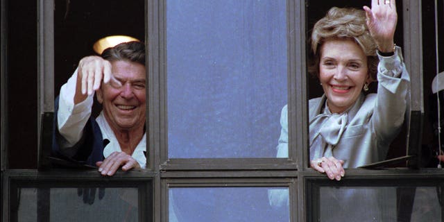 July 18, 1985: President Ronald Reagan and Nancy Reagan wave from the windows of his hospital room at the Navy Medical Center.