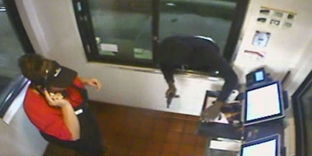 Image from surveillance video showing a man with a gun robbing a McDonald's in Ocala, Fla. (Fox 51 Ocala)