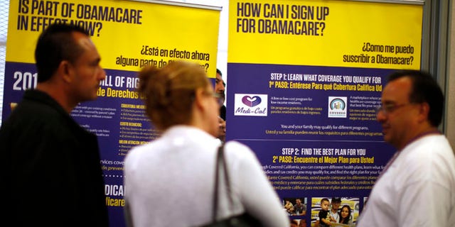 Mar. 31. 2014: Julian Gomez (R) explains Obamacare to people at a health insurance enrolment event in Commerce, California. (Reuters)
