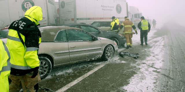 FEb. 14, 2015: First responders check on occupants of a multi-vehicle accident in near white out conditions, blocks west bound I-70.
