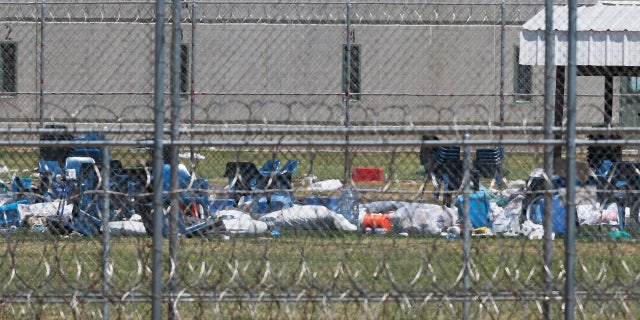 Chairs and debris in the prison yard are pictured through layers of wire at the Great Plains Correctional Facility in Hinton, Okla, Monday, July 10, 2017.