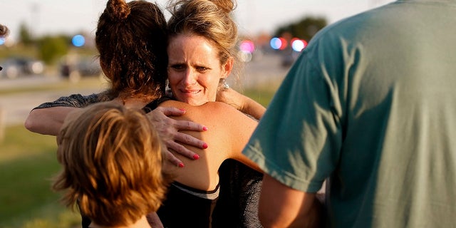 Jennifer Stong hugs Tasha Hunt outside the scene of a shooting on the east side of Lake Hefner in Oklahoma City, Thursday, May 24, 2018.