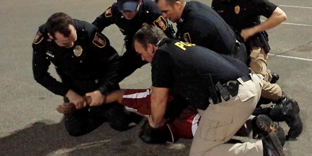 Police restraining Luis Rodriguez.