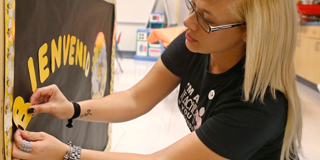 July 31, 2015: Odaliz Soto, of San Sebastian, Puerto Rico, makes a sign welcoming her kindergarten students at Parmelee Elementary School in Oklahoma City. Soto is one of 14 bilingual teachers recruited from Puerto Rico by the Oklahoma City School District to serve their ever-growing Spanish-speaking population, and reduce teacher vacancies.