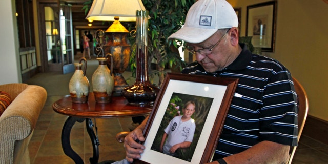 May 22, 2013: Marvin Dixon, the grandfather of 8-year-old tornado victim Kyle Davis, glances down at a photo of his grandson while sitting for a portrait in the lobby of a funeral home where his grandson awaits burial, in Oklahoma City.