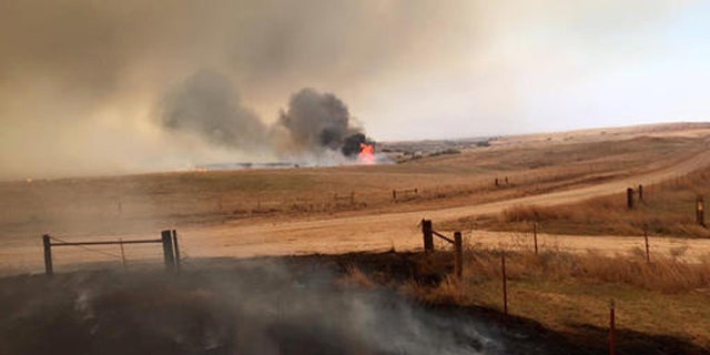 This April 5, 2016 photo provided by Landon Cates, volunteer firefighters from the Dewey County Task Force work a blaze southwest of Freedom, Okla. Oklahoma Forestry Services Director George Geissler says arcing power lines are to blame for the blaze in northwest Oklahoma, located about 170 miles northwest of Oklahoma City. (Landon Cates/Leedy Fire Department via AP)