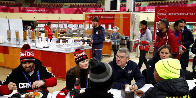 International Olympic Committee President Thomas Bach, second from right, visits with members of the Canadian and Jamaican Olympic teams as they eat lunch during a tour of the Pyeongchang Olympic Village prior to the 2018 Winter Olympics in Pyeongchang, South Korea, Monday, February 5, 2018