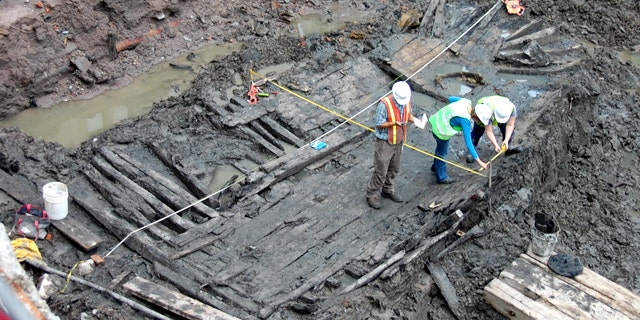 Workers at the World Trade Center in downtown Manhattan analyze a 32-foot-long ship hull found early Tuesday.