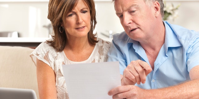 Mature couple worrying about finances at home
