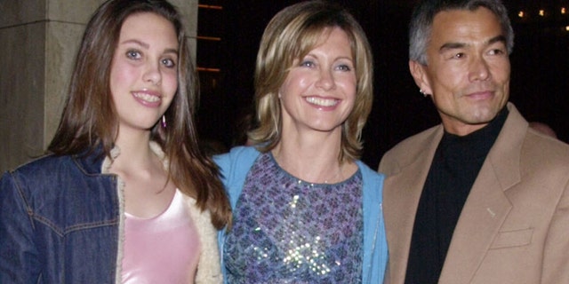Singer and actress Olivia Newton-John (C) poses with her daughter Chloe and Patrick McDermott upon arriving February 26, 2001 for the opening night of "Mamma Mia!" at the Los Angeles Shubert Theatre. REUTERS
