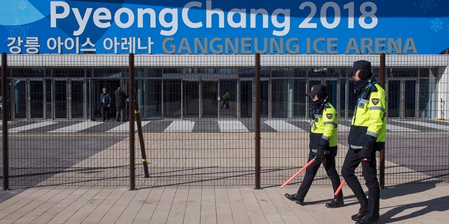 Police officers walk the perimeter of the Gangneung Ice Arena where the figure skating and short track speed skating will be held during the Pyeungchang Winter Olympics Monday, Feb. 5, 2018 in Gangneung, South Korea. (Paul Chiasson/The Canadian Press via AP)