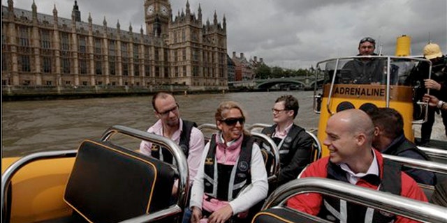 July 4, 2012: People are seen aboard a high-speed 12-seater rigid inflatable boat, run by the Protection Services International company as it travels past the Palace of Westminster on London's river Thames.