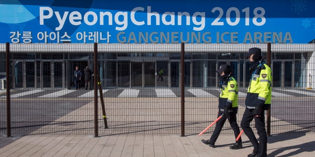 Police officers walk the perimeter of the Gangneung Ice Arena where the figure skating and short track speed skating will be held during the Pyeungchang Winter Olympics Monday, Feb. 5, 2018 in Gangneung, South Korea. (Paul Chiasson/The Canadian Press via AP)