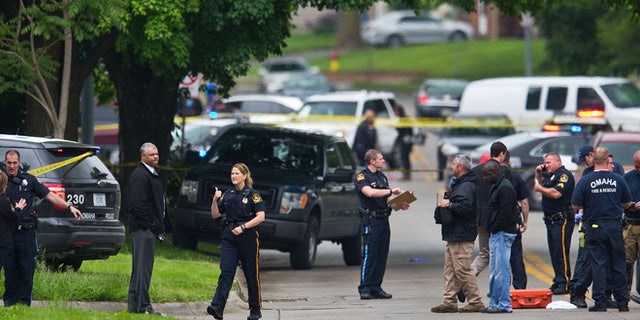 Law enforcement officers gather near the scene of a shooting Wednesday, May 20, 2015 in Omaha, Neb. Police say one female officer and at least one other person were shot and are being treated at an Omaha hospital. (Chris Machian/Omaha World-Herald via AP) MAGS OUT TV OUT