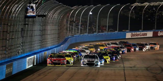 AVONDALE, AZ - NOVEMBER 15: Jimmie Johnson, driver of the #48 Lowe's Patriotic Chevrolet, and Kurt Busch, driver of the #41 Haas Automation Chevrolet, lead the field to the green flag at the start of the NASCAR Sprint Cup Series Quicken Loans Race for Heroes 500 at Phoenix International Raceway on November 15, 2015 in Avondale, Arizona. (Photo by Chris Trotman/Getty Images)