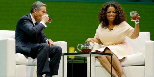 March 19, 2014: Howard Schultz, left, chairman and CEO of Starbucks Coffee Company, sits and drinks tea with Oprah Winfrey, right, to announce their partnership to offer Teavana Oprah Chai tea, Wednesday.