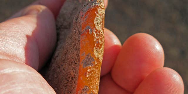 This undated photo provided by the University of Oregon Museum of Natural and Cultural History shows a scraper chipped out of agate found at an ancient rock shelter in the high desert of eastern Oregon.