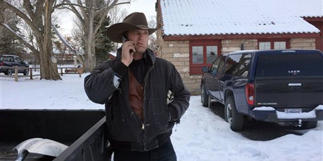 Ryan Bundy talks on the phone at the Malheur National Wildlife Refuge near Burns, Ore., Sunday, Jan. 3, 2016. Bundy is one of the protesters occupying the refuge to object to a prison sentence for local ranchers for burning federal land. (AP Photo/Rebecca Boone)