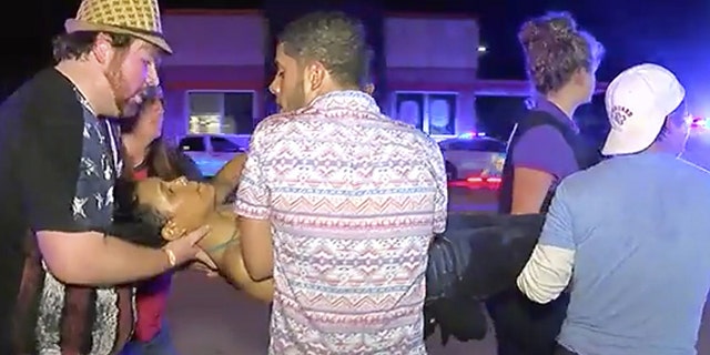An injured person is escorted out of the Pulse nightclub after a shooting rampage, Sunday morning June 12, 2016, in Orlando, Fla.