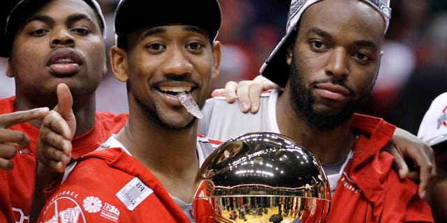 March 13: Ohio State forward Dallas Lauderdale, right, and David Lighty carry the championship trophy as Deshaun Thomas, left, looks on after Ohio State defeated Penn State 71-60 in an NCAA college basketball game in the championship of the Big Ten Conference tournament in Indianapolis. (AP)