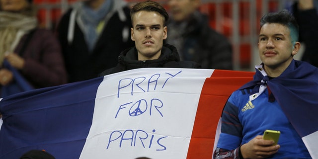 A man holds a French flag ahead of the international friendly soccer match between England and France at Wembley Stadium in London, Tuesday, Nov. 17, 2015. France is playing England at Wembley on Tuesday after the countries decided the match should go ahead despite the deadly attacks in Paris last Friday night which killed scores of people. (AP Photo/Kirsty Wigglesworth)