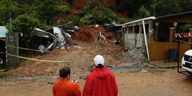 Civil Defense workers look the area where a couple was killed after their home was destroyed by a mudslide in Arraijan on the outskirts of Panama City, Tuesday, Nov. 22, 2016. Civil defense officials in Panama say the country has already seen three deaths blamed on late-season Tropical Storm Otto. (AP Photo/Arnulfo Franco)