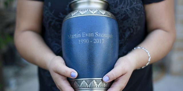 2015: A Staten Island, N.Y. mother holds an urn filled with the ashes of her son, who died of a drug overdose.