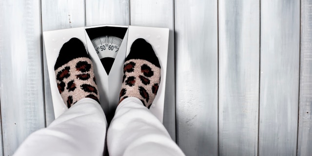 Woman on scale in casual clothes
