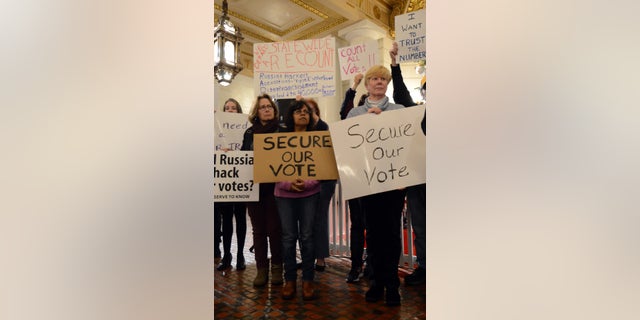 Participants listen to a speaker at a rally at the Pennsylvania Capitol in support of a Green Party-backed quest for a recount of Pennsylvania's Nov. 8 presidential election, Monday, Dec. 5, 2016, in Harrisburg, Pa. (AP Photo/Marc Levy)