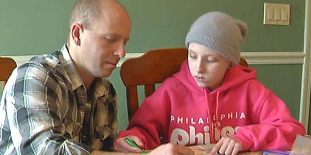 Paige gets help from her father Shane on her schoolwork.