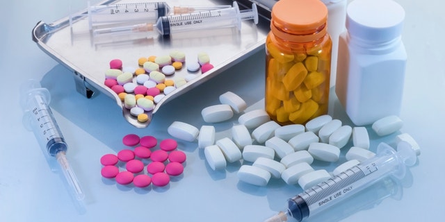 Medical background with pill, syringe, and bottles