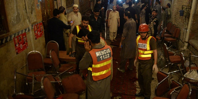 Pakistani rescue volunteers visit at a site of blast in Peshawar, Pakistan, Tuesday, July 10, 2018. Police in Pakistan say a suicide bomber has killed a secular party leader and many supporters during an election rally in the northwestern city of Peshawar. (AP Photo/Muhammad Sajjad)