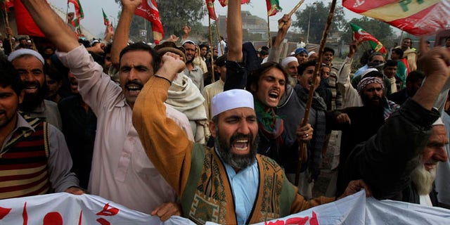 Nov. 23, 2013: Supporters of Tehreek-e-Insaf or Movement for Justice party chant anti-U.S. slogans during a rally in Peshawar, Pakistan. Thousands of people protesting U.S. drone strikes blocked a road in northwest Pakistan used to truck NATO troop supplies and equipment in and out of Afghanistan, the latest sign of rising tension caused by the attacks.
