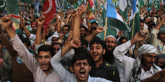 Nov. 24, 2013: Supporters of the Pakistani religious party Jammat-e-Islami and Tehreek-e-Insaf party, headed by cricketer-turned politician Imran Khan, hold up their parties' flags and chant slogans during a rally against U.S. drone strikes in Pakistani areas, in Karachi, Pakistan.