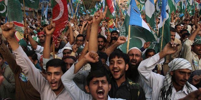 Nov. 24, 2013: Supporters of the Pakistani religious party Jammat-e-Islami and Tehreek-e-Insaf party, headed by cricketer-turned politician Imran Khan, hold up their parties' flags and chant slogans during a rally against U.S. drone strikes in Pakistani areas, in Karachi, Pakistan.