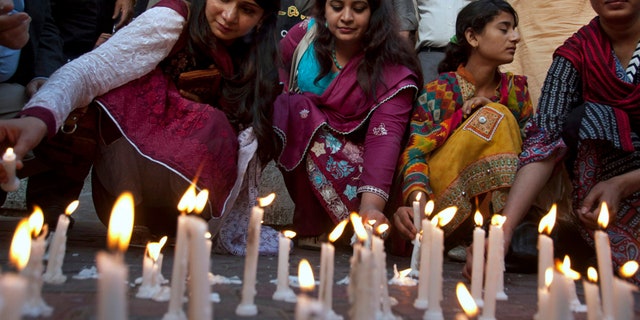 Members of a civil society group light candles during a vigil for the victims of the Lahore suicide bombing, in Karachi, Pakistan.