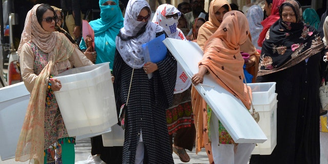 Pakistani election workers collect ballot boxes and polling material from a distribution center in Quetta, Pakistan, Tuesday, July 24, 2018.