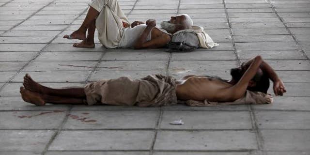June 22, 2015: Men sleep in shade under a bridge during intense hot weather in Karachi, Pakistan.