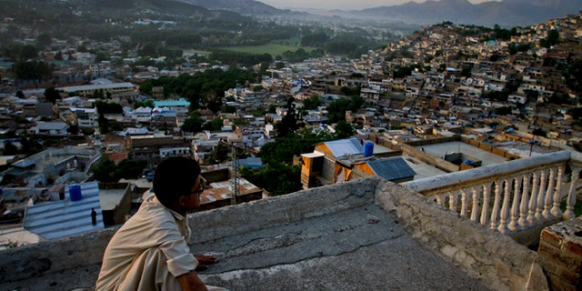 In this May 15, 2011 file photo, Ali Raza sits on the rooftop of his house as he views the city of Abbottabad, Pakistan. Pakistani officials say the government plans to build a recreation complex in the town.