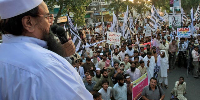 Sept. 30, 2012: Hafiz Saeed, leader of Pakistani religious group Jamaat-ud-Dawa, left, delivers a speech during a protest against a film insulting the Prophet Muhammad, in Lahore, Pakistan.