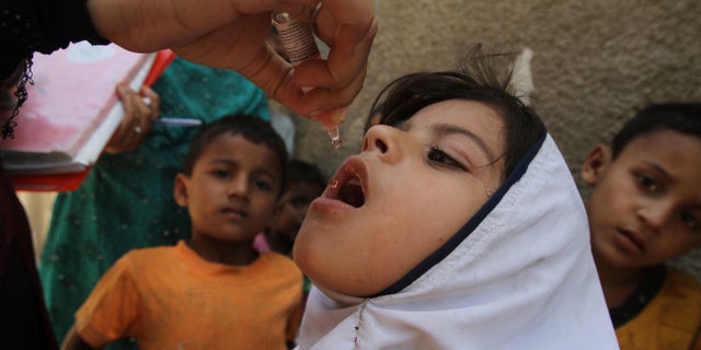 FILE - In this April 21, 2016 file photo, a Pakistani health worker gives a polio vaccine to a girl during a campaign in Karachi, Pakistan. For the first time in Pakistan's history all the previous month's environmental samples for polio have tested negative, a sign of progress in the campaign to eradicate the virus, an official said Monday, May 30, 2016. (AP Photo/Fareed Khan, File)