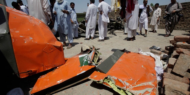 May 17, 2012: People on a rooftop look at a wreckage of a plane which crashed in Nowshera, 21 miles east of Peshawar, Pakistan.