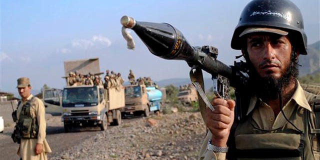 A Pakistani paramilitary soldier secures an area as other troops move toward a forward base during a military operation against militants in the Khurram tribal region July 9.
