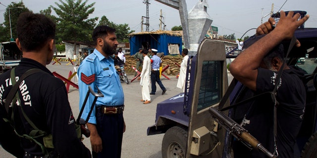 Aug. 16, 2012: Pakistani police commandos wait to enter an air force base in Kamra, about 50 miles northwest of Islamabad, Pakistan. At least half a dozen militants attacked the air force base with suspected link to the country's nuclear program before dawn Thursday, sparking a heavy battle that killed two security personnel and left parts of the base in flames, officials said. (AP)