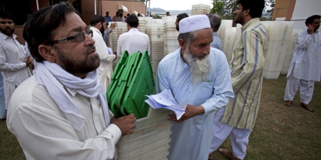 May 10, 2013: Pakistani election staff carry ballot boxes for tomorrow;s elections in Islamabad, Pakistan.