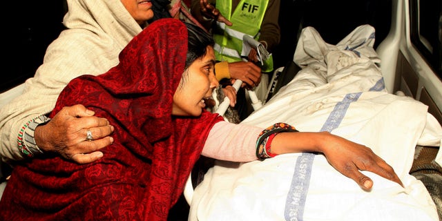 Dec. 29, 2014: A Pakistani woman mourns over the dead body of a family member after a fire broke out in a building, in Lahore, Pakistan