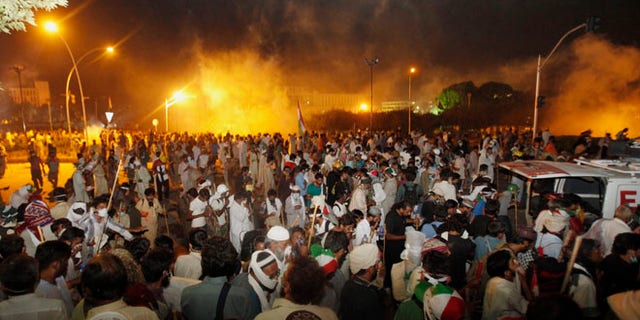 Aug 30, 2014: Pakistani protesters run after police fire tear gas during clashes near the prime minister's home in Islamabad, Pakistan. (AP)
